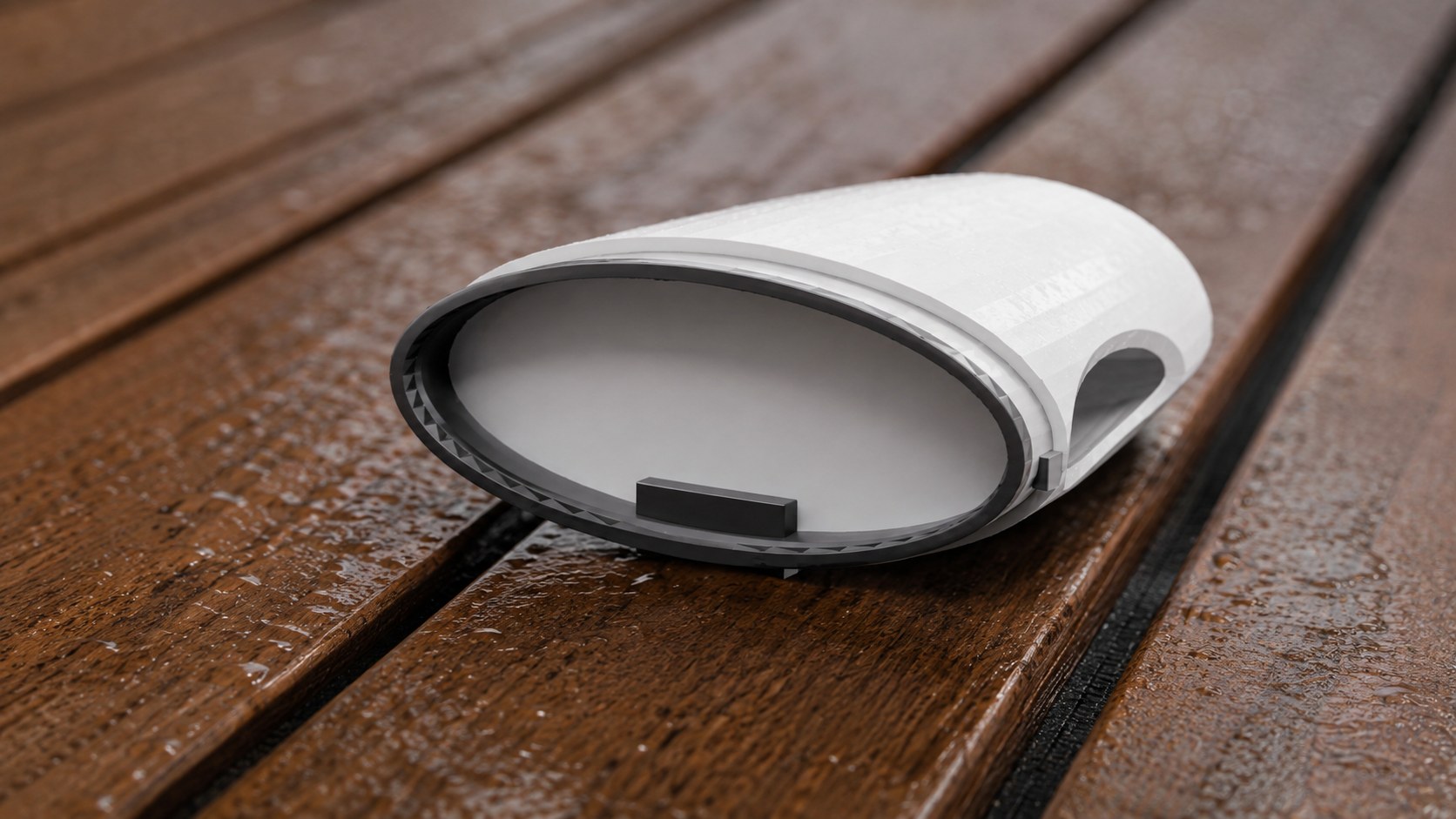 A camera pod cartridge lying on a wet deck.